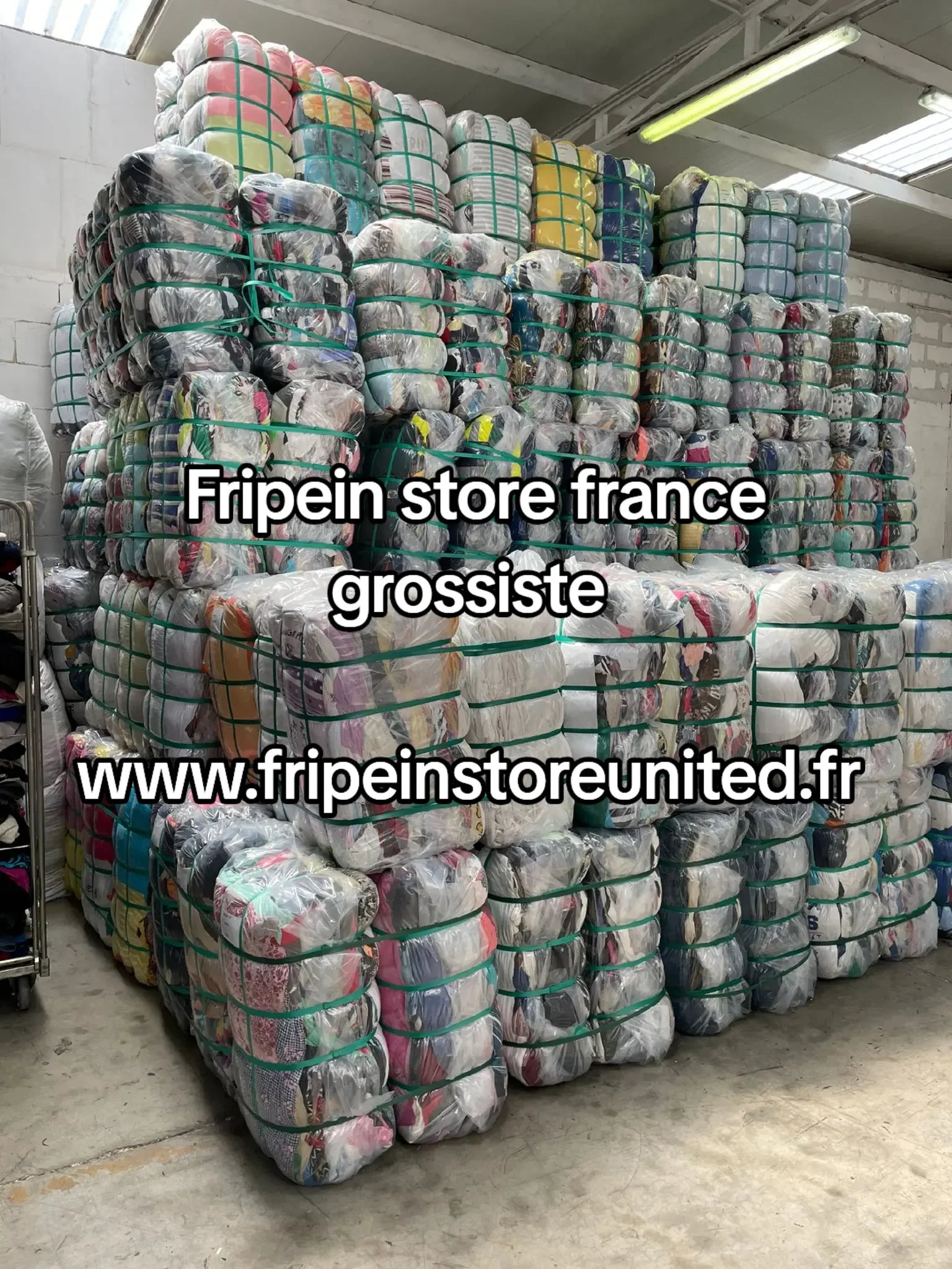 Entrepôt intérieur rempli de balles de textiles compressées, emballées dans du plastique transparent.