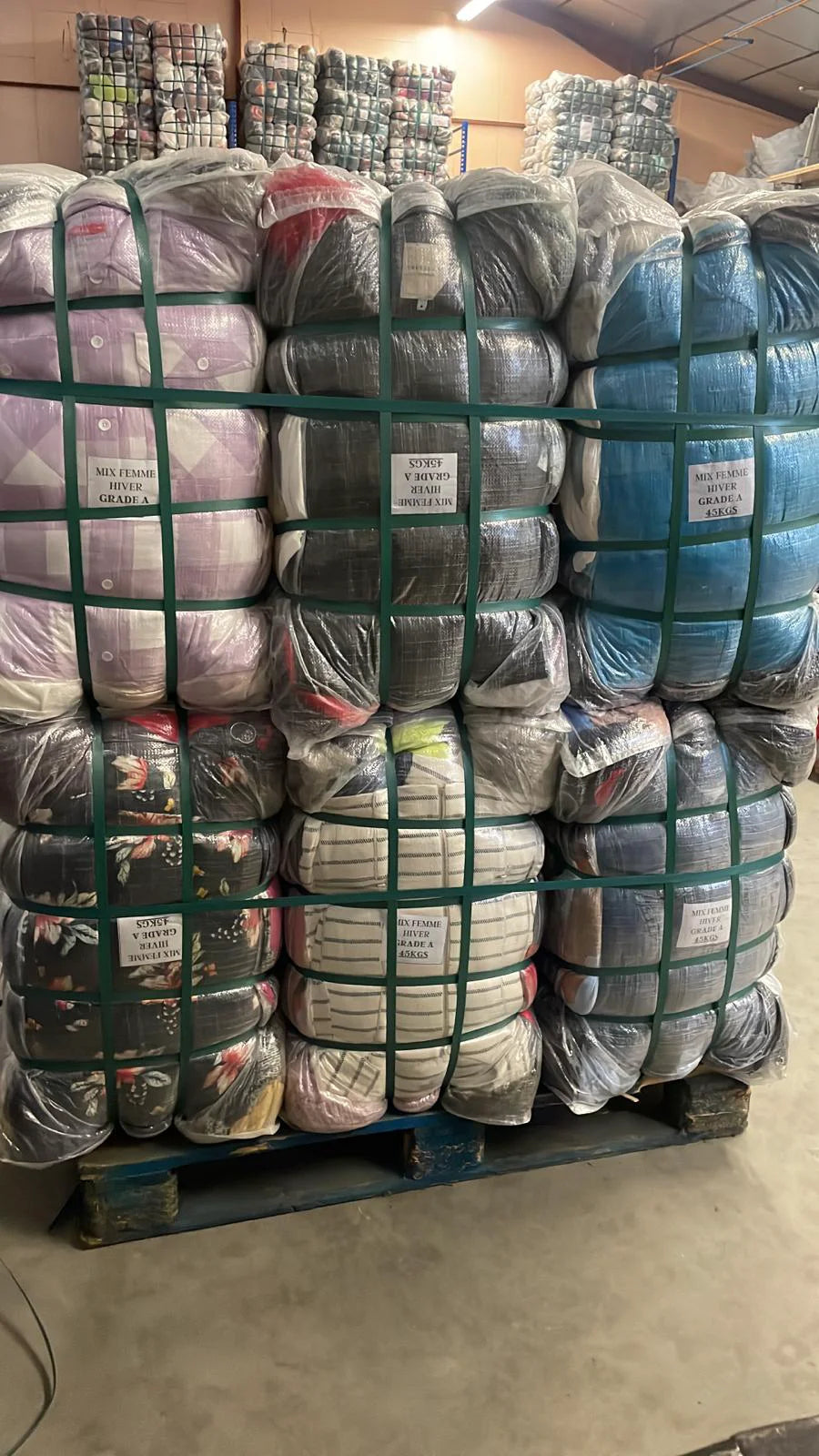 Palette de lots textiles compressés et filmés dans un entrepôt de vente en gros